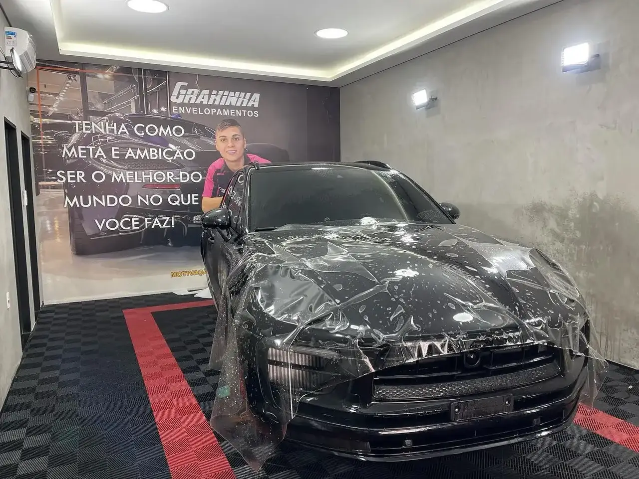 Porsche Macan durante aplicação do PPF — filme de proteção sendo posicionado sobre a carroceria
